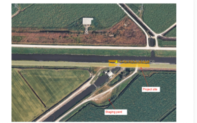 Aerial view of a canal and adjacent fields with labels marking the project site and staging yard.